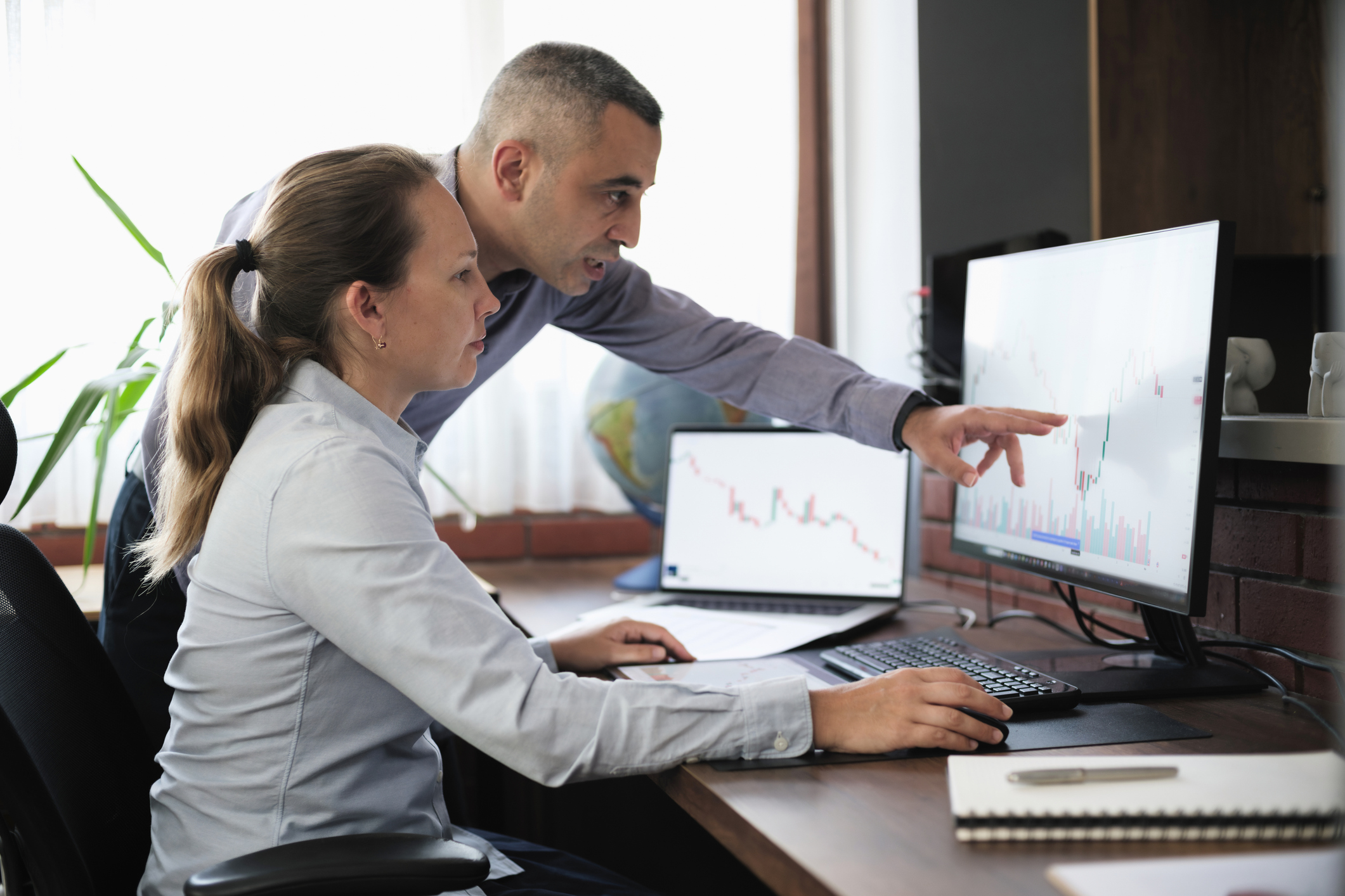 Businesspeople working in the office on stock market exchange data using desktop computer and digital tablet